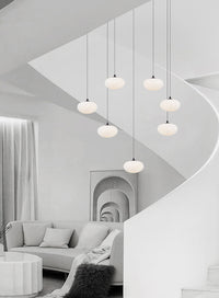 multi milk ball chandelier in Nordic style is hanging from ceiling besides a spiral staircase in the loft