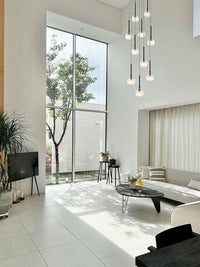 Gracing a stately foyer, Aurorae’s pendant light welcomes guests with its warm, elegant radiance.